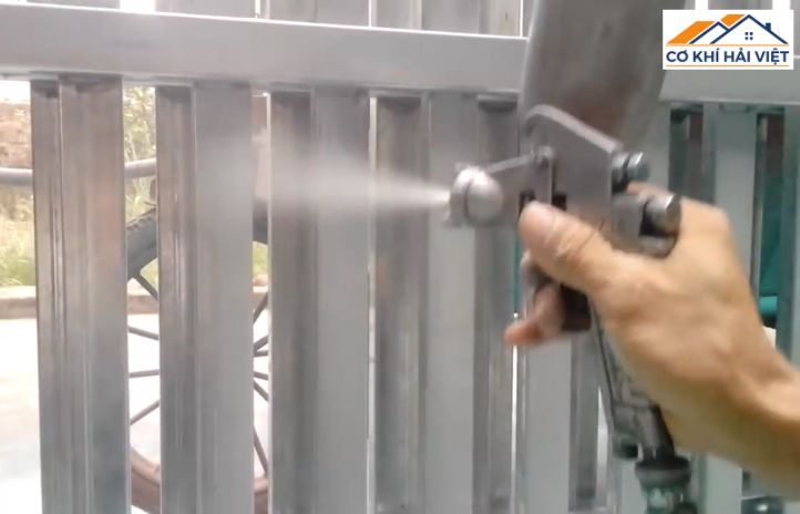 Thợ sơn đang thi công lớp sơn lót chống rỉ cho cửa sắt