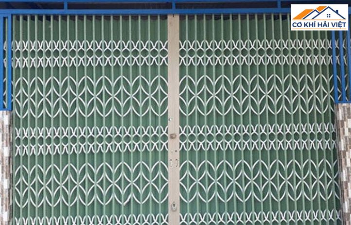 Mẫu cửa sắt kéo có lá màu xanh ngọc, tạo sự kín đáo cho một cửa hàng