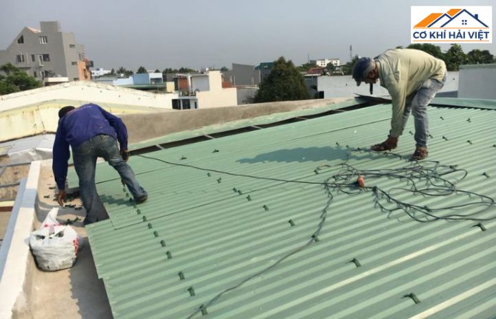 Đội thợ chuyên nghiệp đang thi công lợp mái tôn cho nhà cấp 4