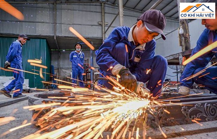 Thợ cơ khí đang hàn một bộ cửa cổng sắt 4 cánh tại xưởng Cơ khí Hải Việt