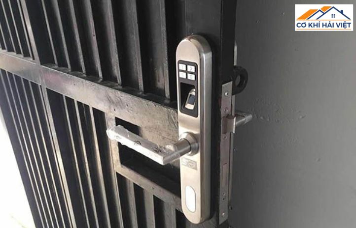 Một ổ khóa tay gạt bằng inox 304 sáng bóng được lắp đặt chắc chắn trên cửa cổng sắt hộp