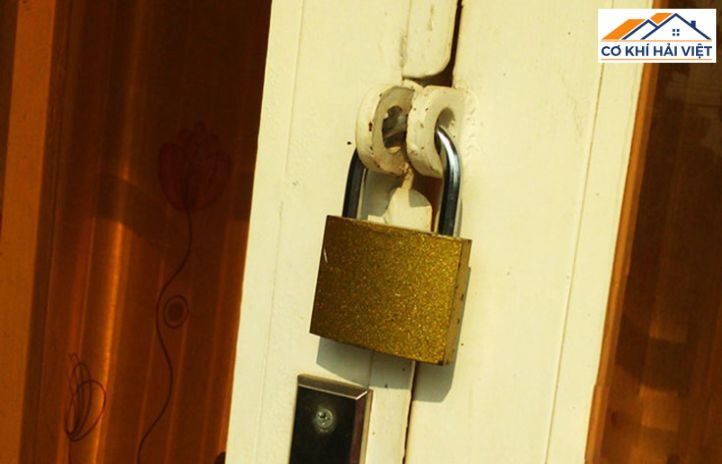 Một ổ khóa móc treo bằng thép chắc chắn đang khóa hai pát cửa lại với nhau