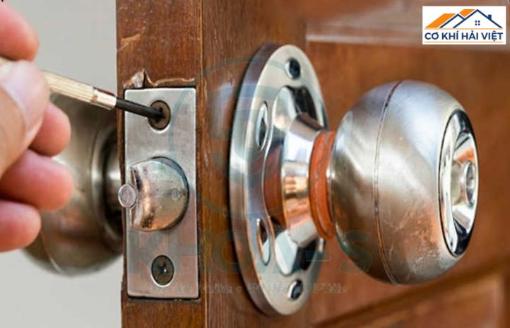 Một ổ khóa nắm tròn bằng inox được lắp trên cửa sắt đơn giản
