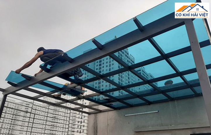 Đội ngũ thợ lành nghề của Cơ Khí Hải Việt đang lắp đặt tấm kính cường lực lên hệ khung