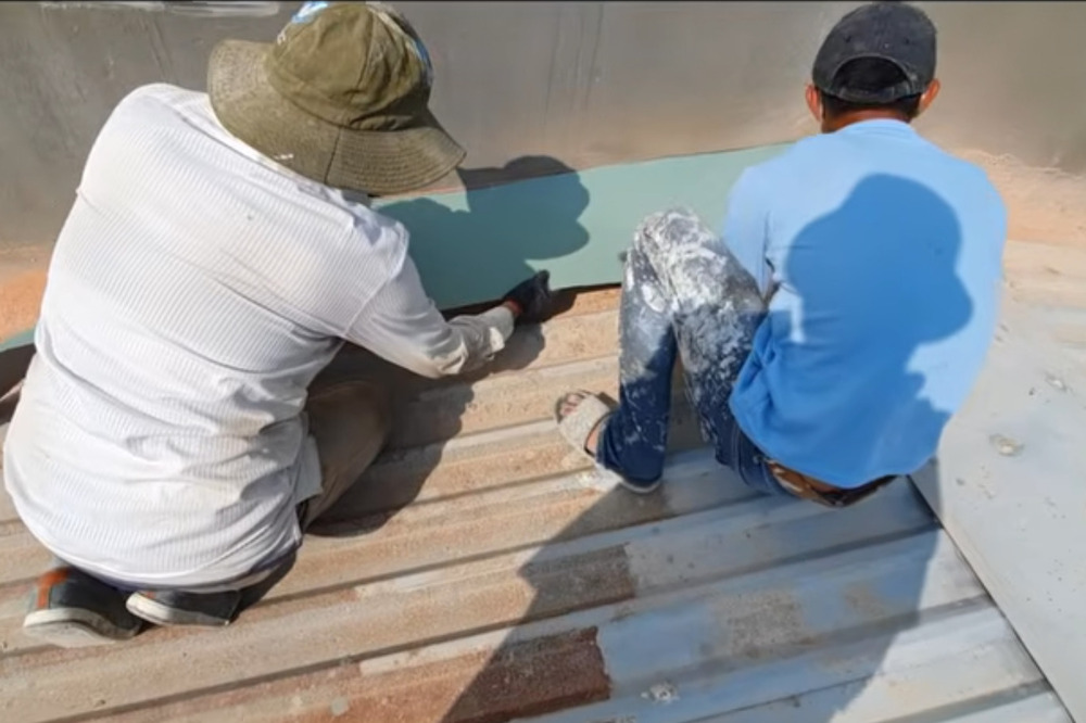 Thợ đang thi công sửa chữa mái tôn cho nhà dân